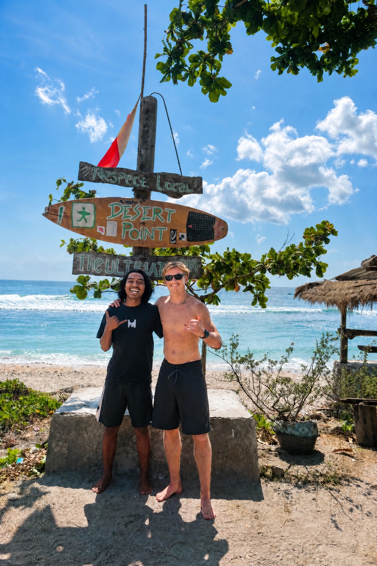 Wawan avec un voyageur et sa planche de surf au bord de l’eau à Gili Air